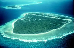 Portion of a  atoll showing two islets on the ribbon or barrier reef separated by a deep pass betwen the ocean and the lagoon.
