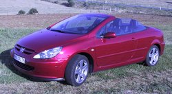 A red Peugeot 307CC coupe-, with a folding steel roof