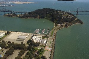 An aerial view of Treasure Island in the foreground, with its link to Yerba Buena Island in the background. Note the San Francisco Bay Bridge's tunnel.
