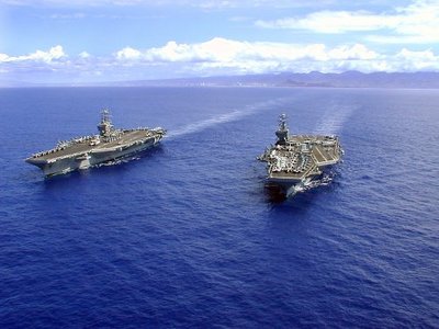Aircraft carriers USS John C. Stennis and USS Abraham Lincoln speed towards Honolulu during RIMPAC 2000.