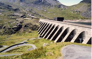 The upper reservoir (Llyn Stwlan) and dam of the Ffestiniog Pumped Storage Scheme in north Wales. The lower power station has four water turbines which generate 360 MW of electricity within 60 seconds of the need arising. The size of the dam can be judged from the car parked below.