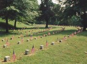 Relatives and others traditionally place flags near veterans' headstones on Memorial Day