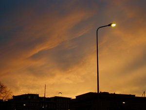 A streetlight in front of a red sky at night