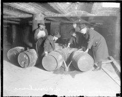Prohibition agents destroying barrels of alcohol.