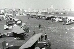 The 1930 National Air Show. Plane 21 is a Cessna monoplane belonging to Eddie August Schneider (1911-1940); and plane 22 behind it is a Viking Kitty Hawk biplane belonging to Nancy Hopkins (1909-1997)