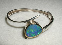 The opal in this bracelet contains a natural periodic microstructure responsible for its  color.  It is essentially a natural photonic crystal, although it does not have a complete photonic band gap.