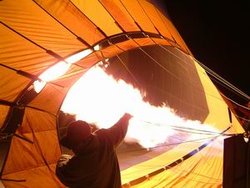 A hot air balloon is prepared for flight by inflation of the envelope with propane burners