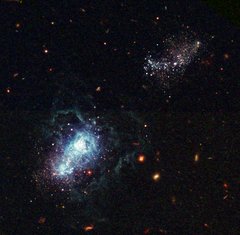 Another Hubble image shows an infant galaxy forming nearby, which means this happened very recently on the cosmological timescale.  This is evidence that the Universe is not quite finished with galaxy formation yet