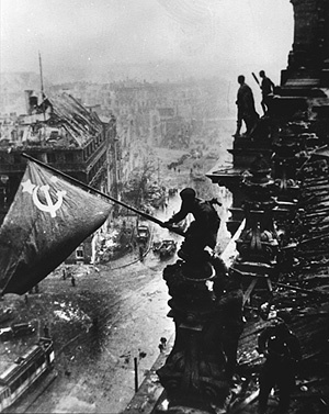 One of 's iconic images is this photo of the Red flag being flown over the  as Berlin falls to the .