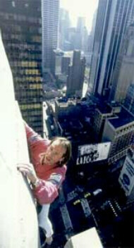 Alain Robert scaling a building with no equipment except his hands and feet.