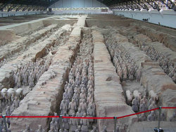 Inside a building showing part of the re-assembled Terracotta Army standing in ranks in the pit.
