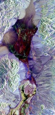 This False-color radar image shows central Death Valley and the different surface types in the area. Radar is sensitive to surface roughness with rough areas showing up brighter than smooth areas, which appear dark. This is seen in the contrast between the bright mountains that surround the dark, smooth basins and valleys of Death Valley. The image shows Furnace Creek  (green crescent feature) at the far right, and the  near Stove Pipe Wells at the center. (NASA image)