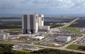An aerial view of the Launch Complex 39 area shows the Vehicle Assembly Building (center), with the Launch Control Center on its right.