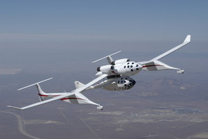  is carried beneath  during a captive carry flight to test SpaceShipOne's  and  performance.  The two-vehicle system can both take off and land in this configuration.