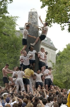 Teamwork: Fourth Class Midshipmen lock arms and use ropes made from uniform items as they brace themselves climbing the Herndon Monument