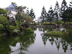 A pond near the main building, which is visible through the trees.