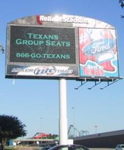 Photograph of a sign at the entrance to the Reliant Park Complex, with Six Flags Astroworld in the background