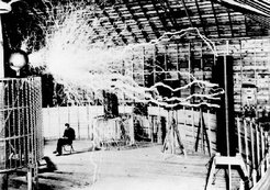 Publicity photo of Tesla sitting in his laboratory in Colorado Springs with his "magnifying transmitter" generating millions of volts of electricity.  The arcs are about 7 meters (22 ft) long. (Tesla's notes identify this as a .)
