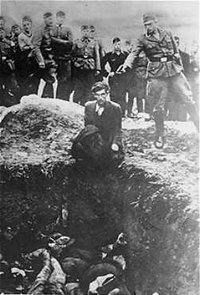 A member of Einsatzgruppe D executes a Jew kneeling before a filled mass grave in Vinnitsa, , in 1942.