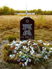 Memorial for Anne and Margot Frank at the former Bergen-Belsen site, along with floral and pictorial tributes.