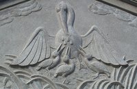 A relief depicting a mother pelican bleeding to feed her chicks