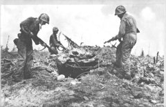 Infantry inspect a hole in the devasted Kwajalein Atoll