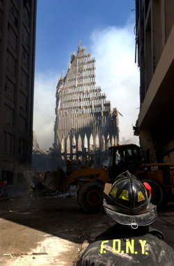 , : A New York City firefighter looks up at what remains of the South Tower.