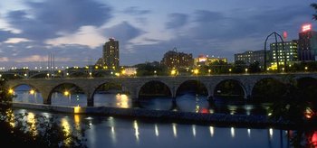 Minneapolis at dusk, featuring the Stone Arch Bridge and the flour mills that were part of the city's initial economy.