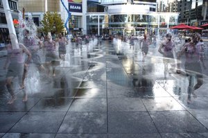 Most bathing is done in hot water or hot steam.  However, splash baths function like a cold shower to help people cool off on hot days.  A jogger is shown, in this  picture, running through the Dundas Square  to cool down.