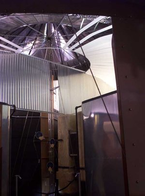 Interior of Dymaxion House showing structural details. Visible are the partially assembled aluminum ceiling, struts and exterior skin as well as single central post which supports the entire structure and carries utilities and plumbing.