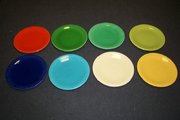 An assortment of Fiestaware plates. The red-orange dish at top left is detectably radioactive due to its uranium-based glaze.