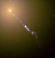 A 5000 light-year (50 Em or 30,000,000,000,000,000 mile) long jet is ejected from active galaxy M87 (the yellow ball at top left). Electrons are ejected outward at near light-speed, emitting eerie blue light.