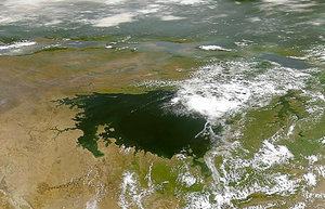 The lake as seen from space, looking west, with others of the Great Lakes forming an arc in the middle distance, and the cloud-covered forests of the Congo beyond.